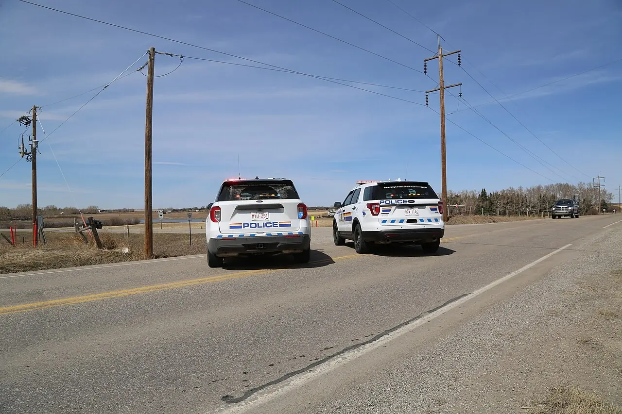 Two RCMP SUVs on a rural road
