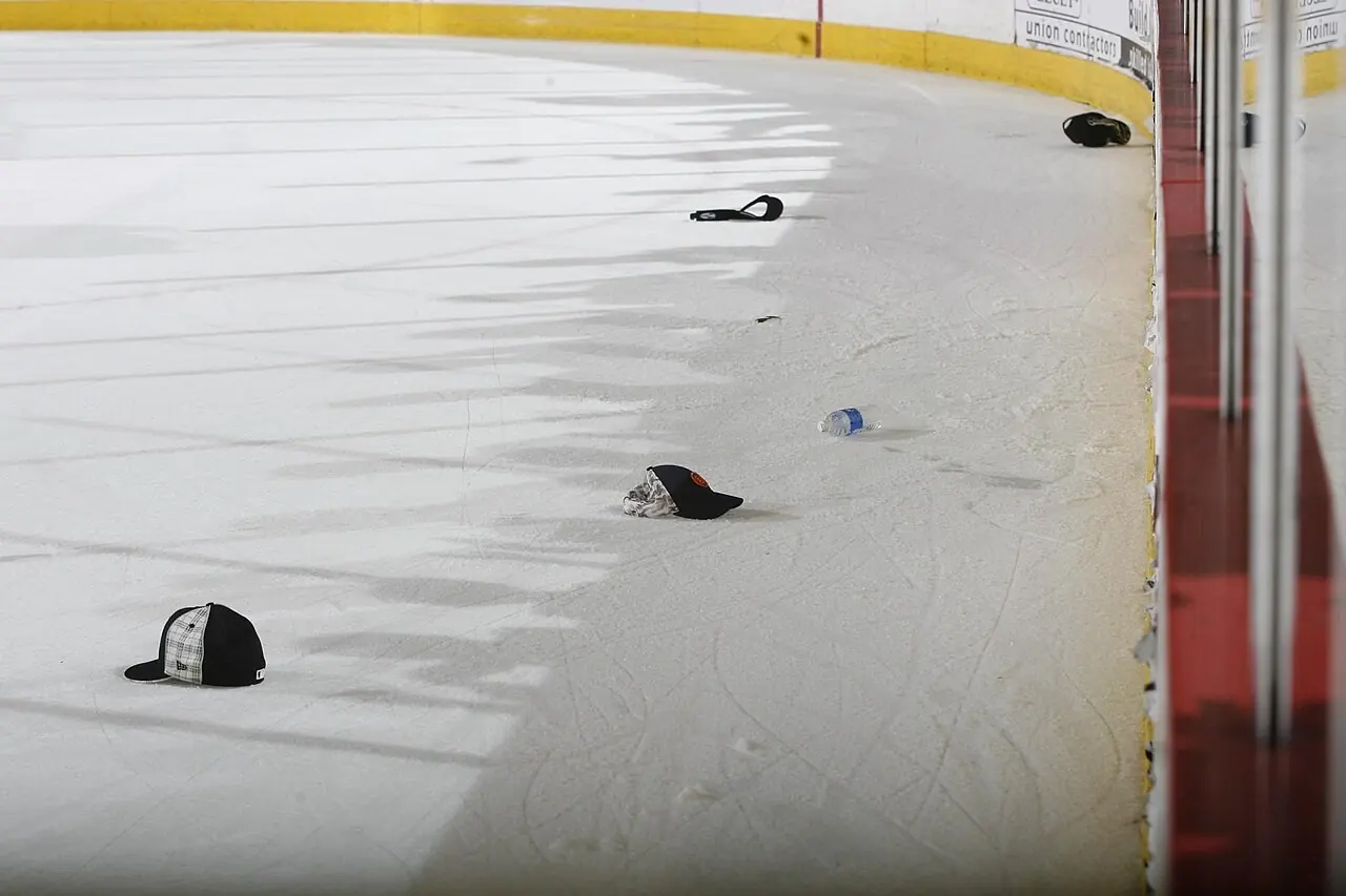 Hats scattered across a hockey rink