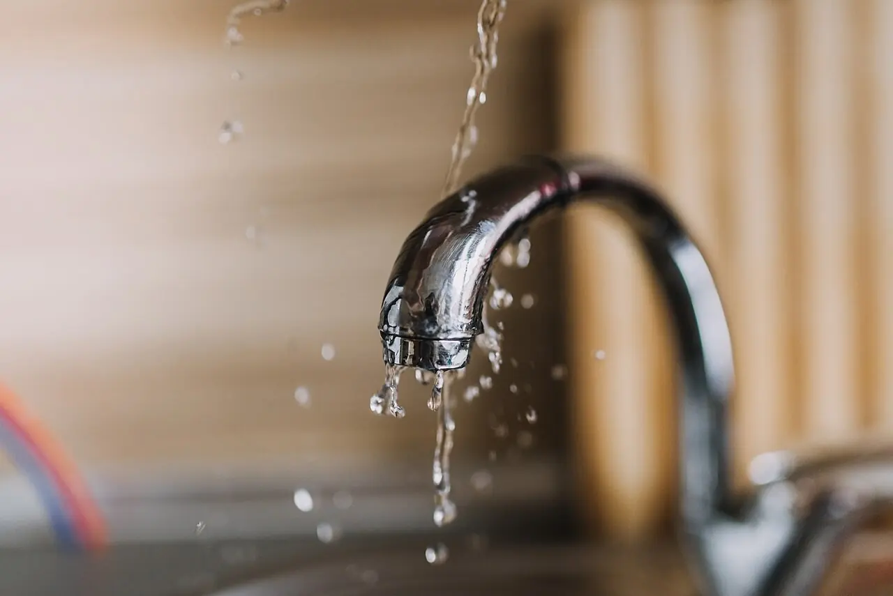 Water dripping from a chrome kitchen faucet
