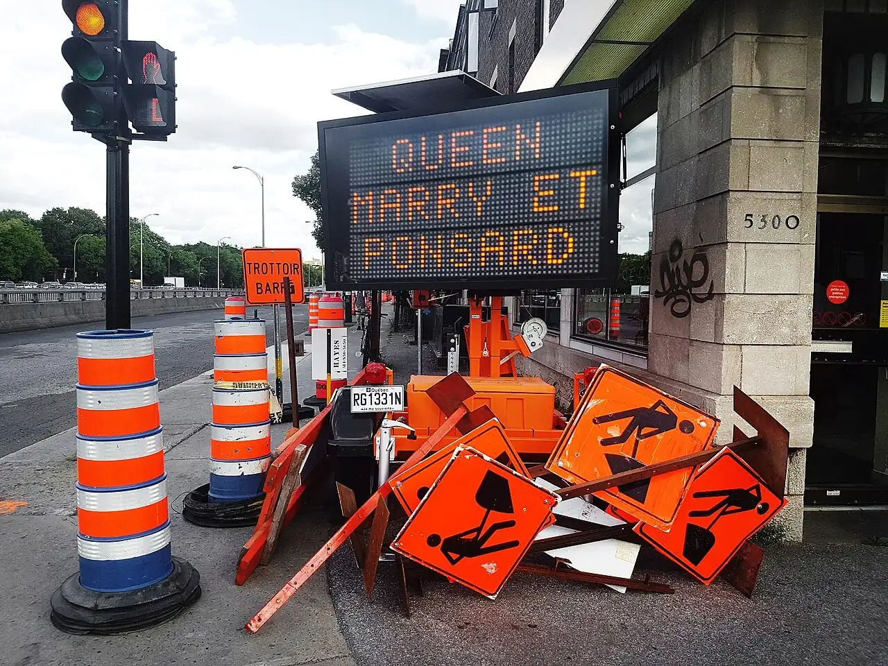Stack of road work signs beside a message board