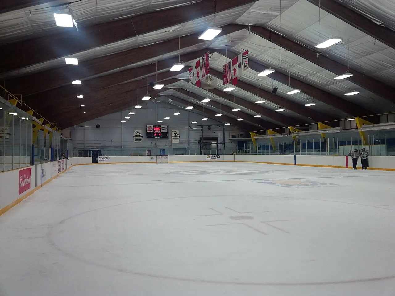 Empty rink in a community arena with a wooden roof