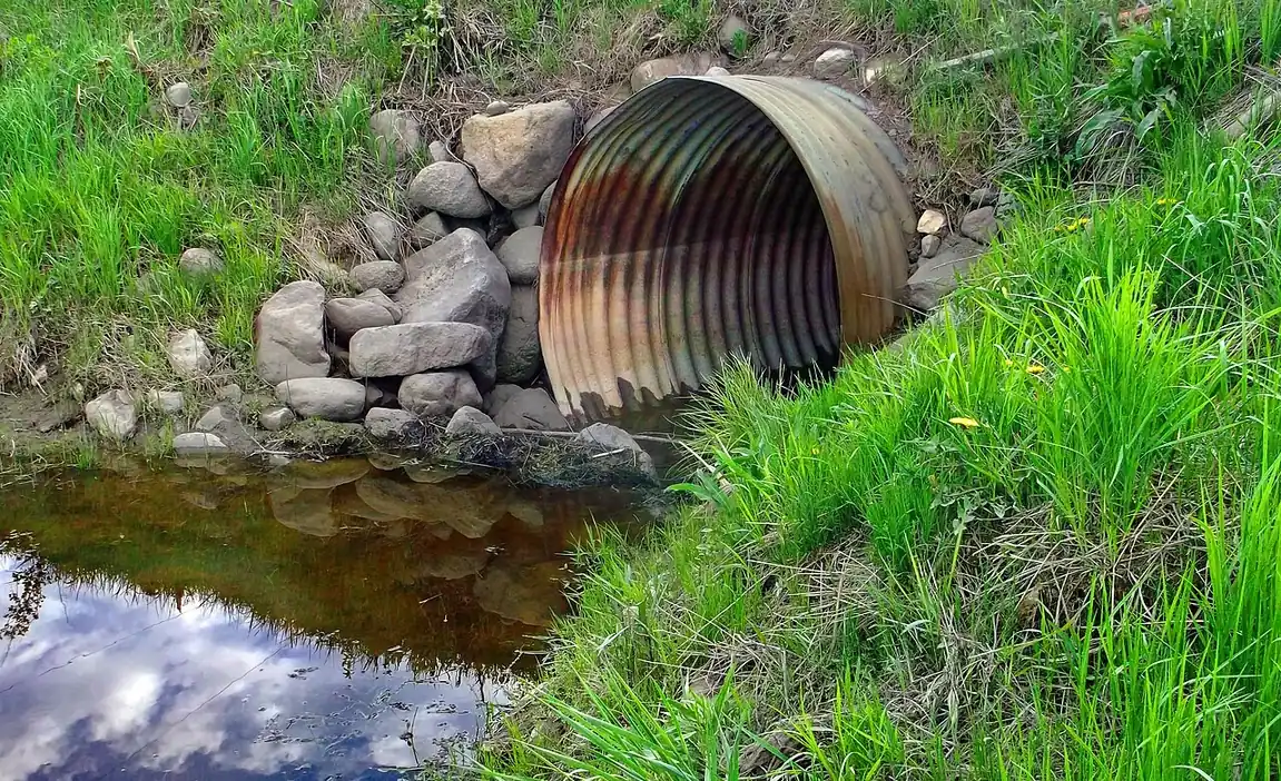 Corrugated culvert pipe draining into a ditch