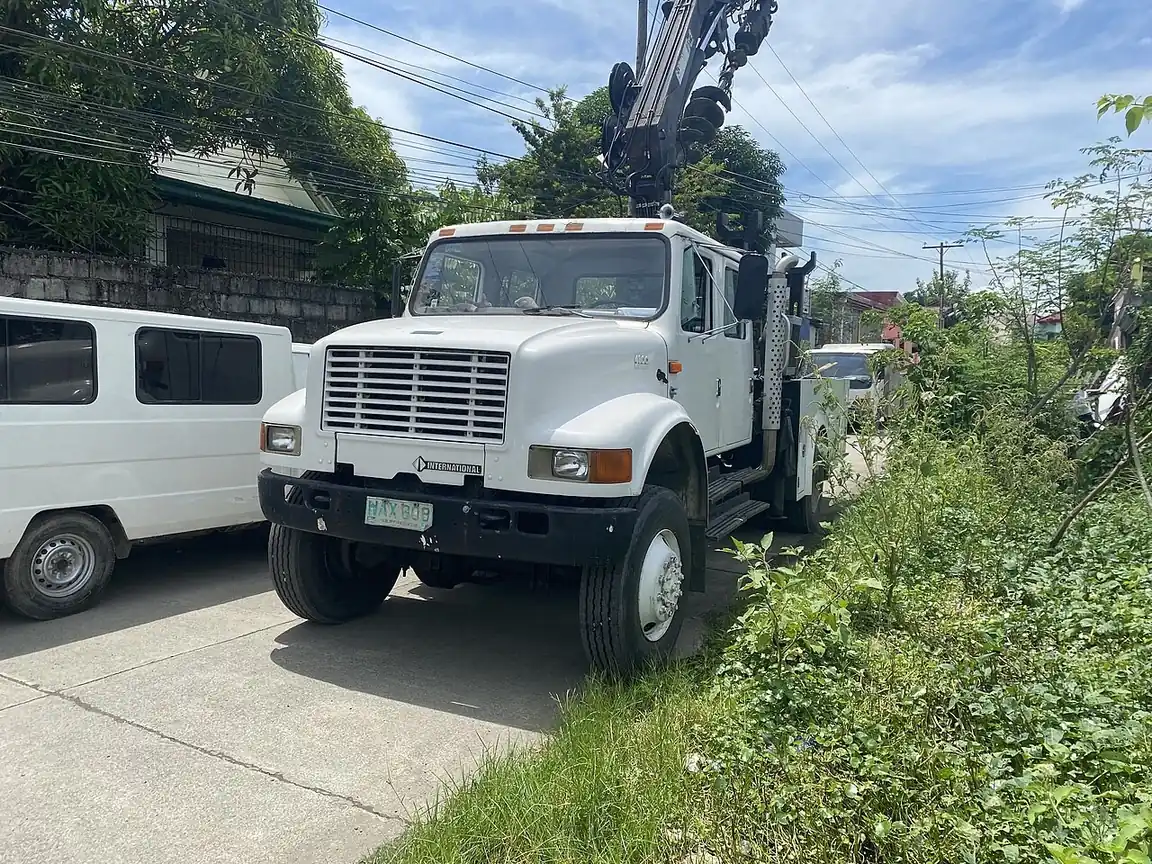 Lineman repair truck parked near a van on a street