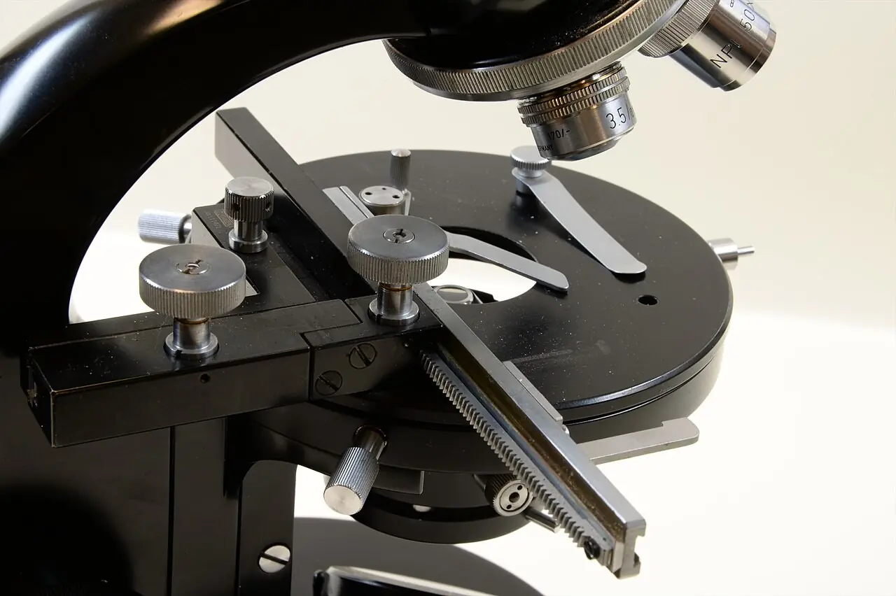 Close-up of a microscope stage and focus dials
