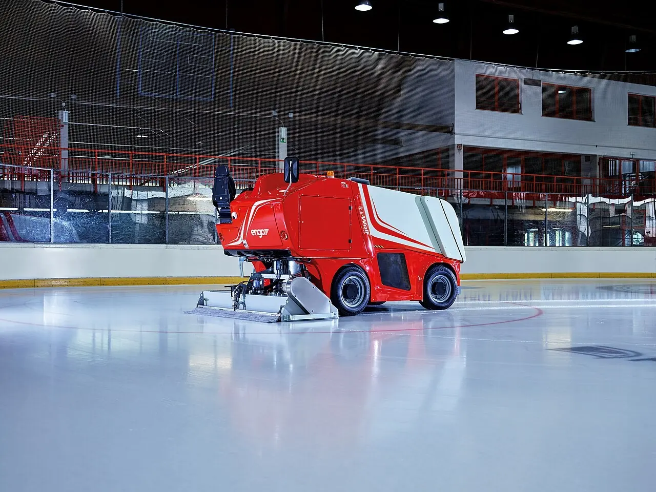 Red electric ice resurfacer on a fresh rink