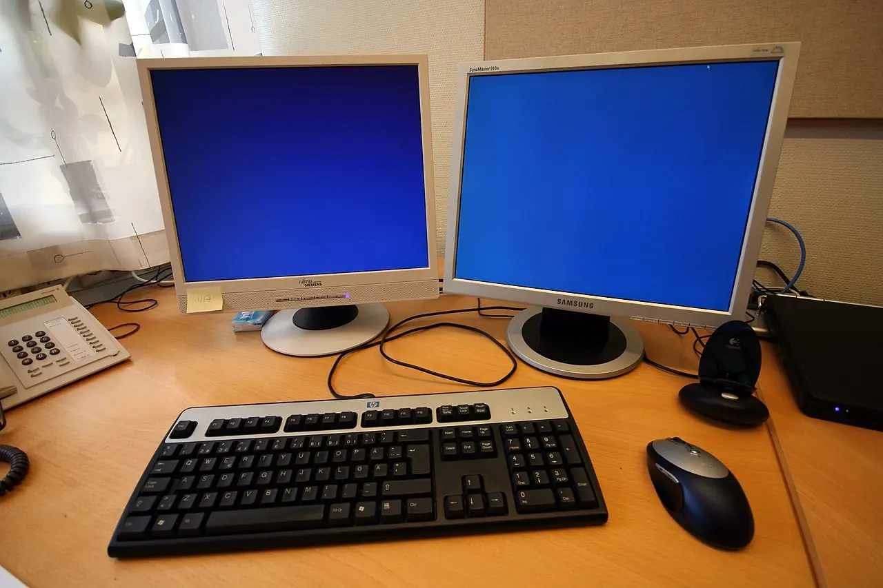 Two computer monitors and a keyboard on an office desk