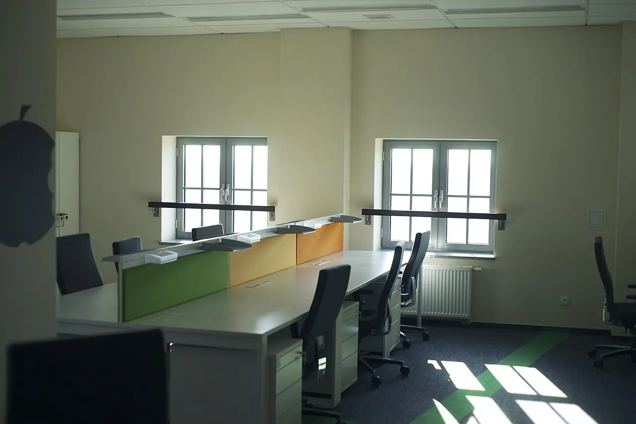 Empty office with rows of desks and chairs