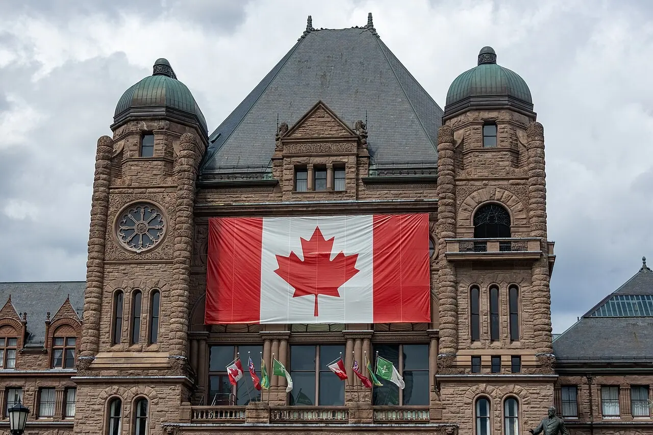 Canadian flag draped over the entrance of the Ontario Legislative Building