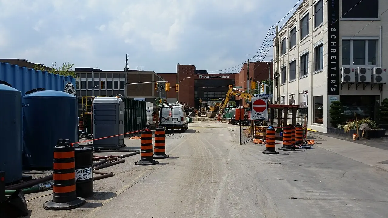 Construction barrels lining a torn-up downtown street